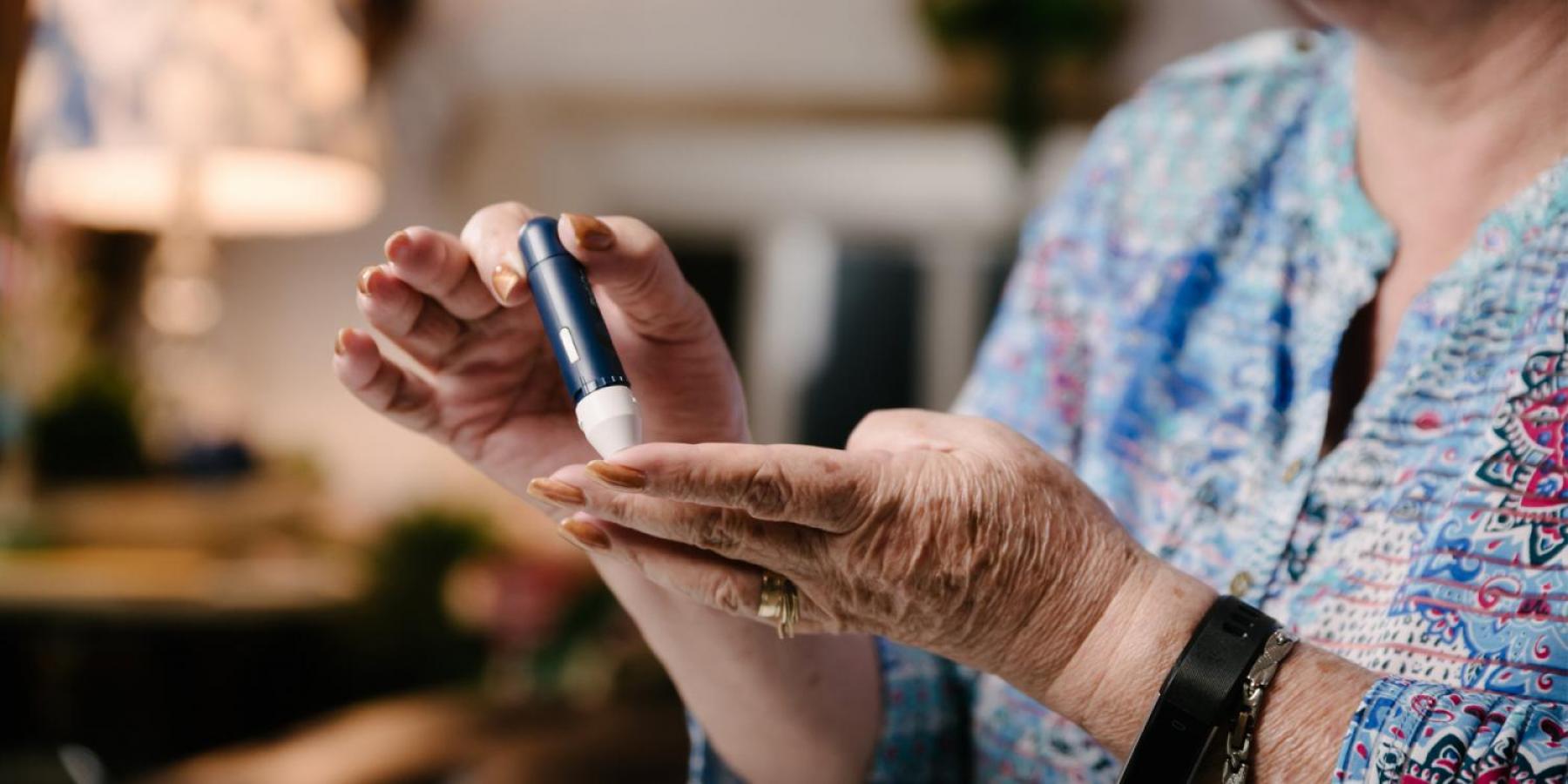 woman taking a sample of her blood using lancet