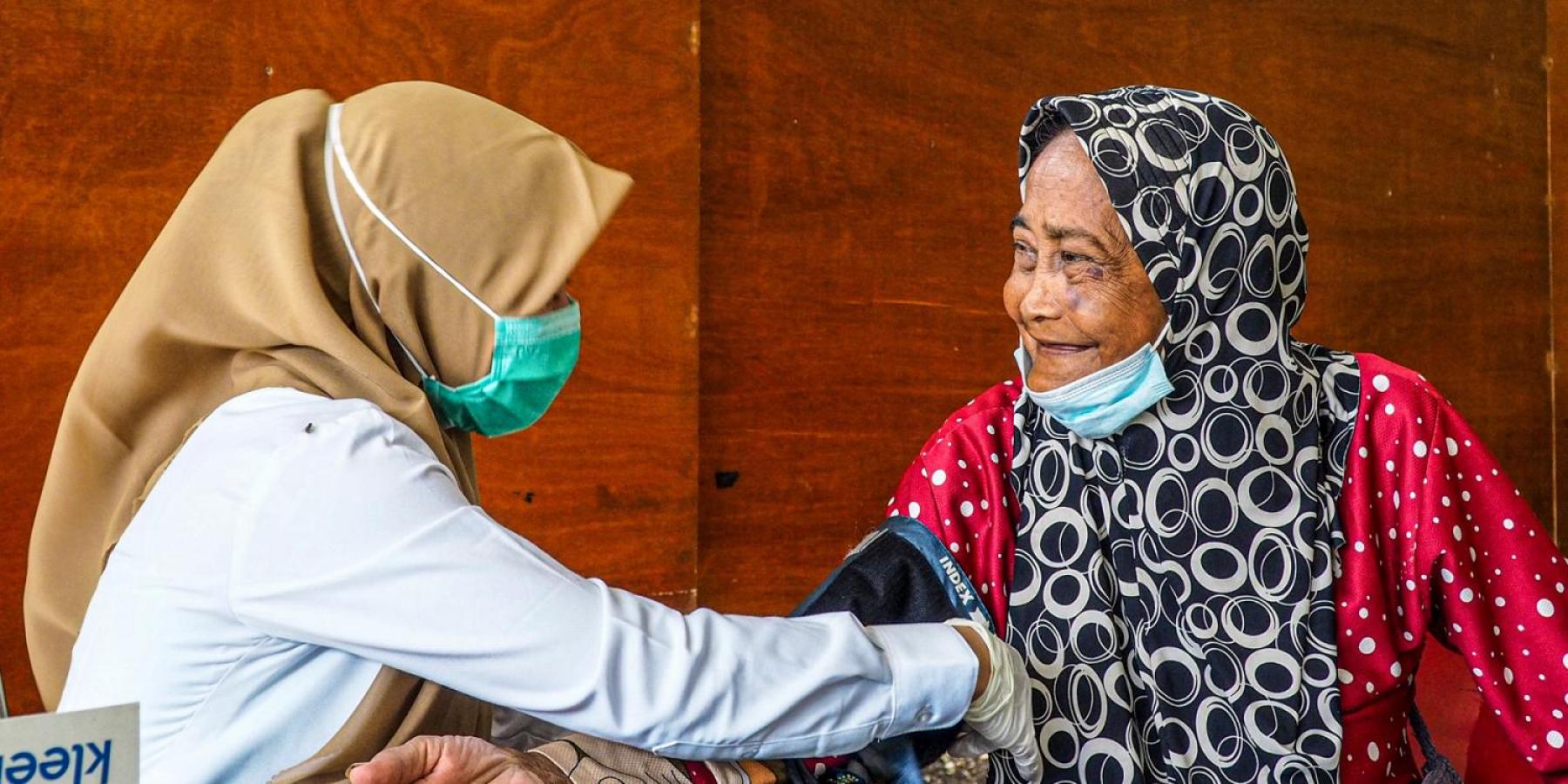 community health worker checking blooding pressure in Asia