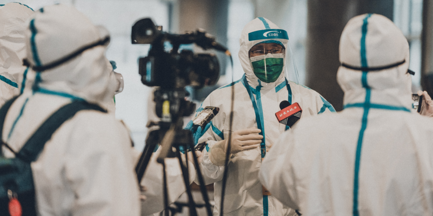 Men in white coat in media briefing. Photo by Unsplash 