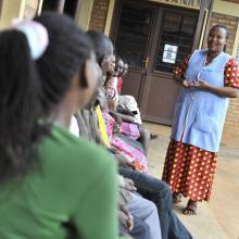 A health worker speaks to clients waiting for services at a clinic in Rwanda