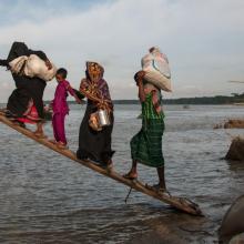 Climate-affected internally displaced persons board a boat to travel to Dhaka, Bangladesh.