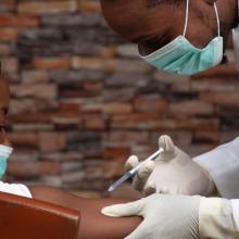 A doctor providing a covid shot in an African setting 